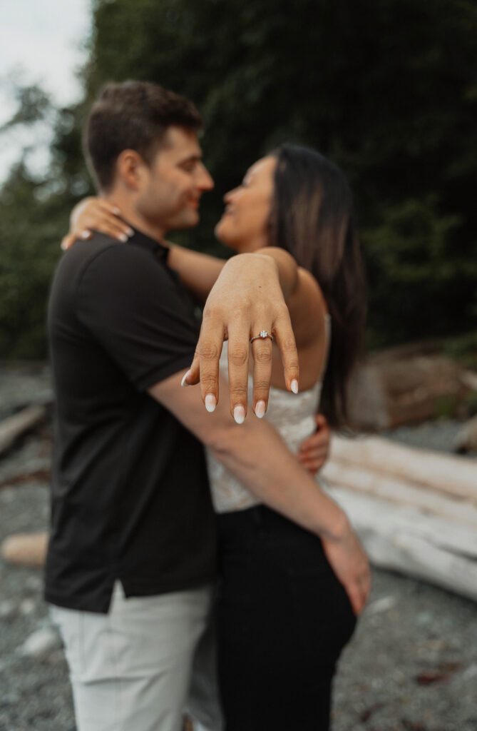 a couple sharing a kiss showing off her engagement ring