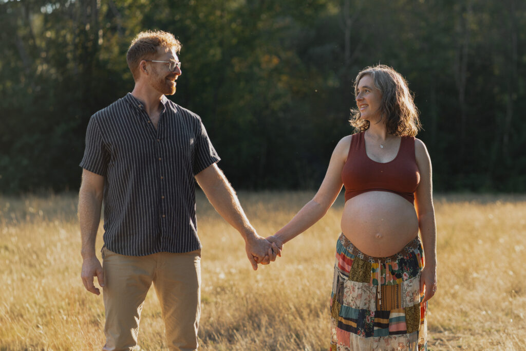 Expecting parents in a field of tall grasses in Comox by Latitude 49 photography