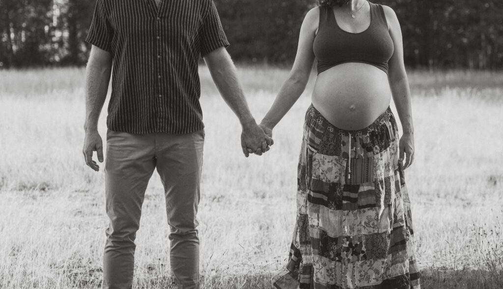 Expecting parents in a field of tall grasses in Comox by Latitude 49 photography