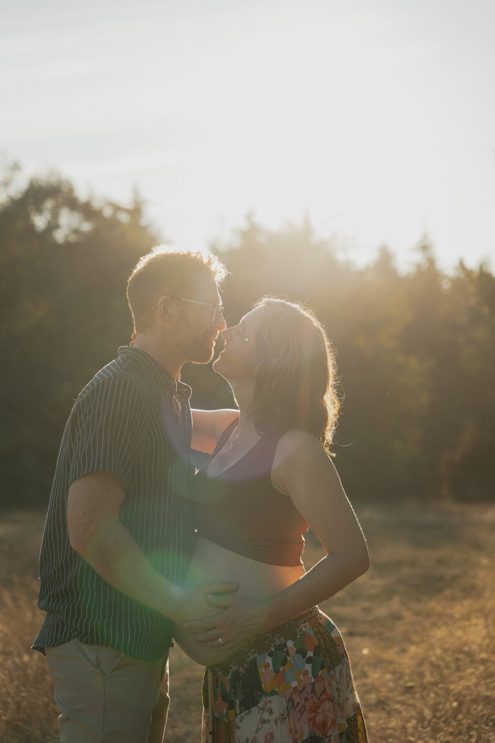 Expecting parents in a field of tall grasses in Comox by Latitude 49 photography