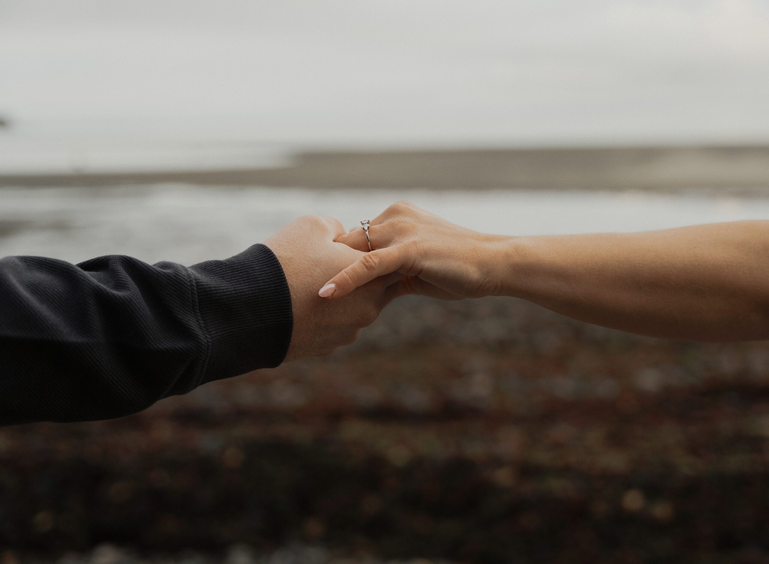 Couple holding hands to show off engagement ring in Comox by Latitude 49 Photography