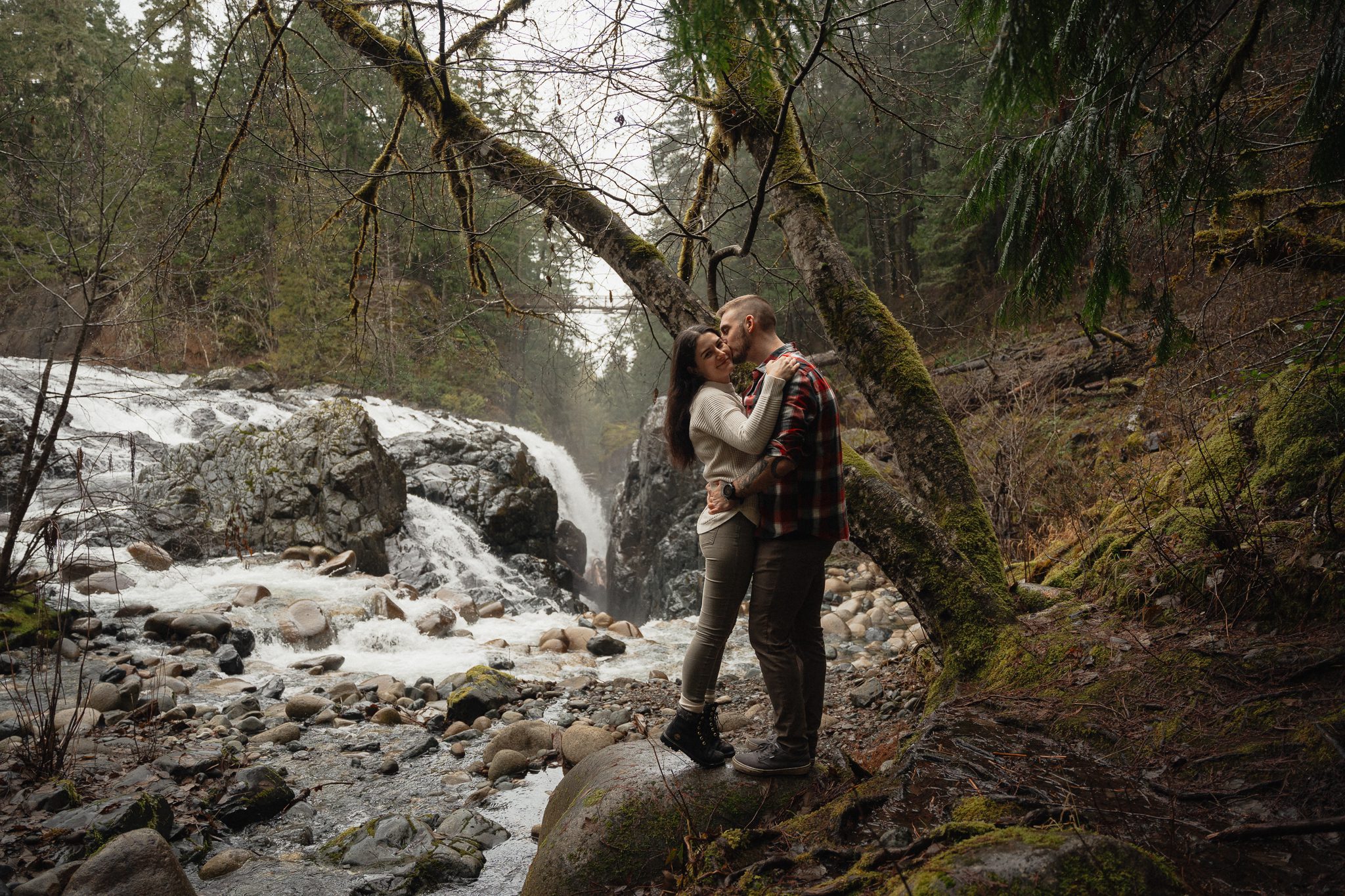 A couples engagement session in front of the waterfalls at Englishman river falls