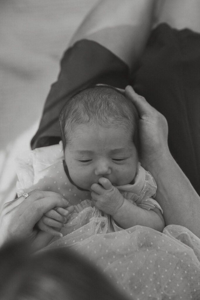 Baby smiling up at mother during relaxed backyard family photoshoot