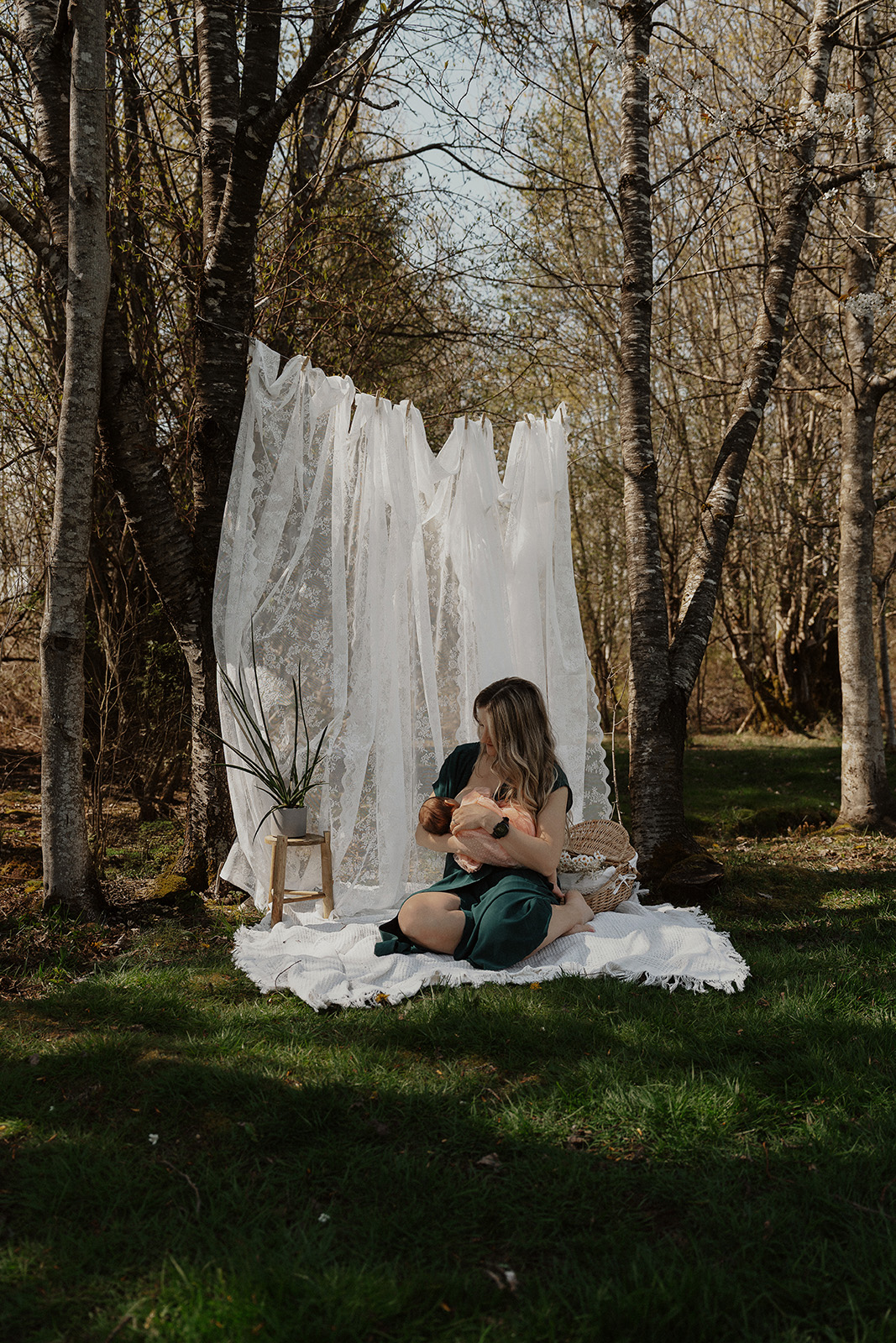 Mother cradling newborn during cozy front yard motherhood session by latitude 49 photography