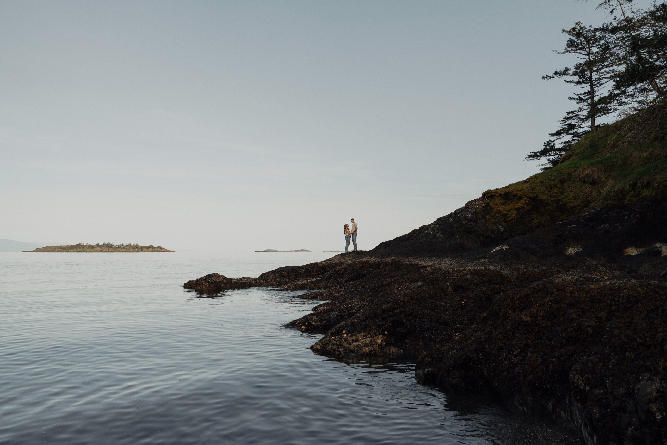 Dakota and James walking on the rocks during their engagement session in Nanoose by Latitude 49 Photography