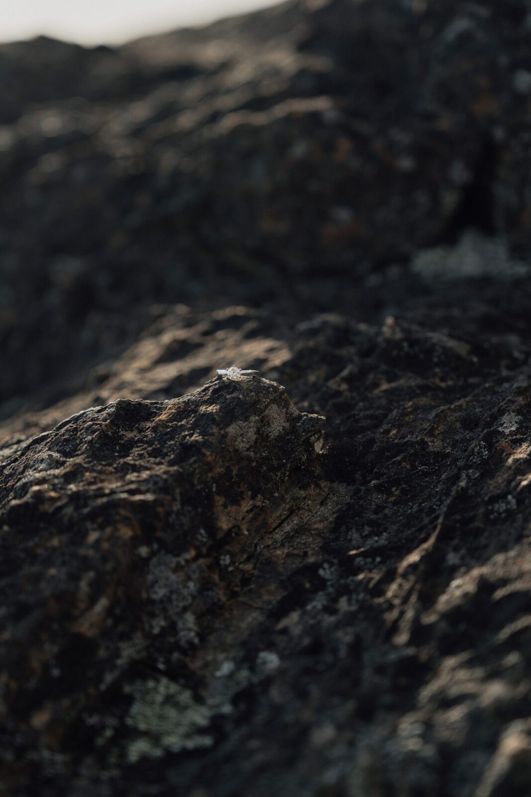 ring on some black rock at Gonzales observatory during an engagement session by Latitude 49 Photography