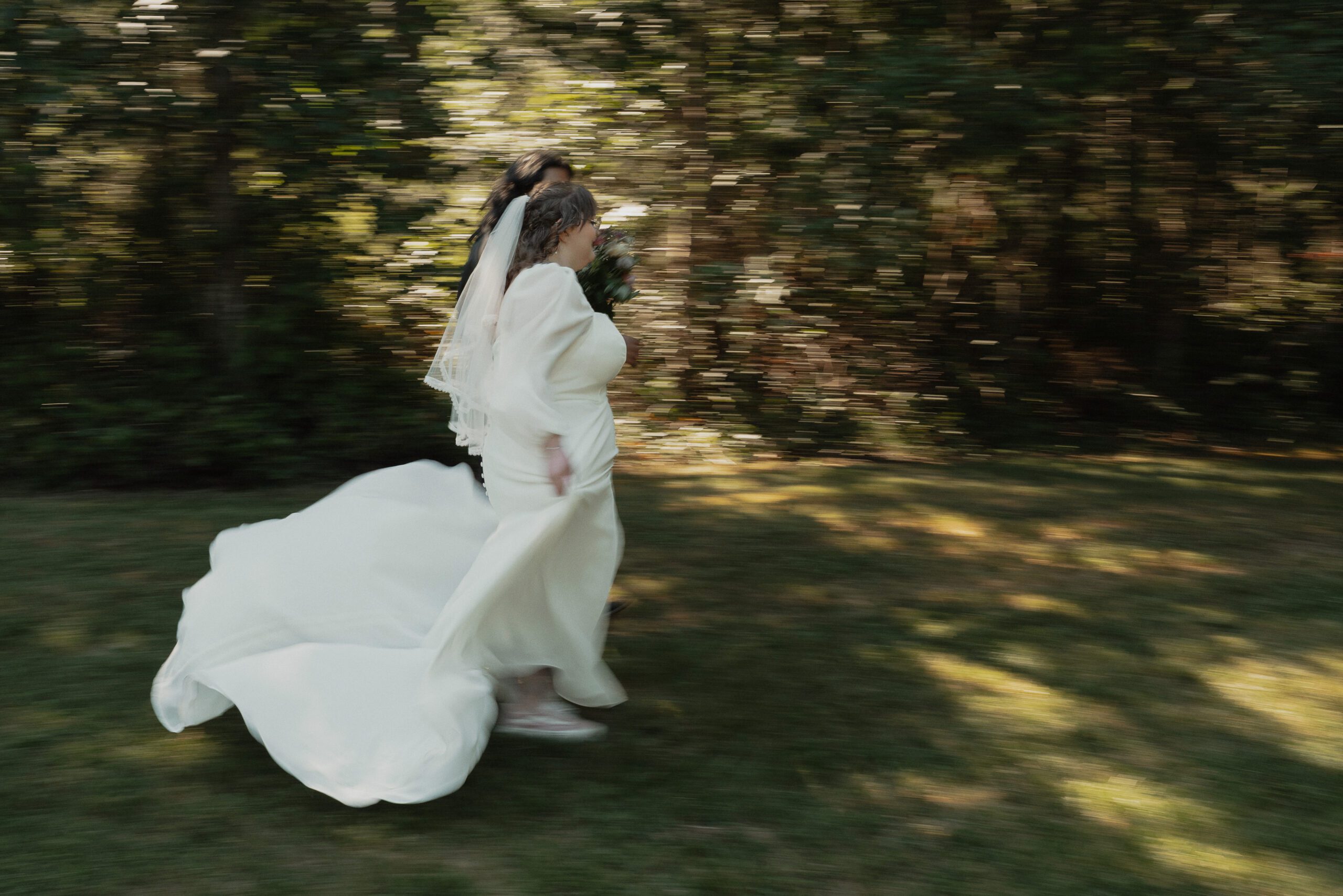 Bride and groom running in forested field during their back yard wedding portraits in Merville by latitude 49 photography