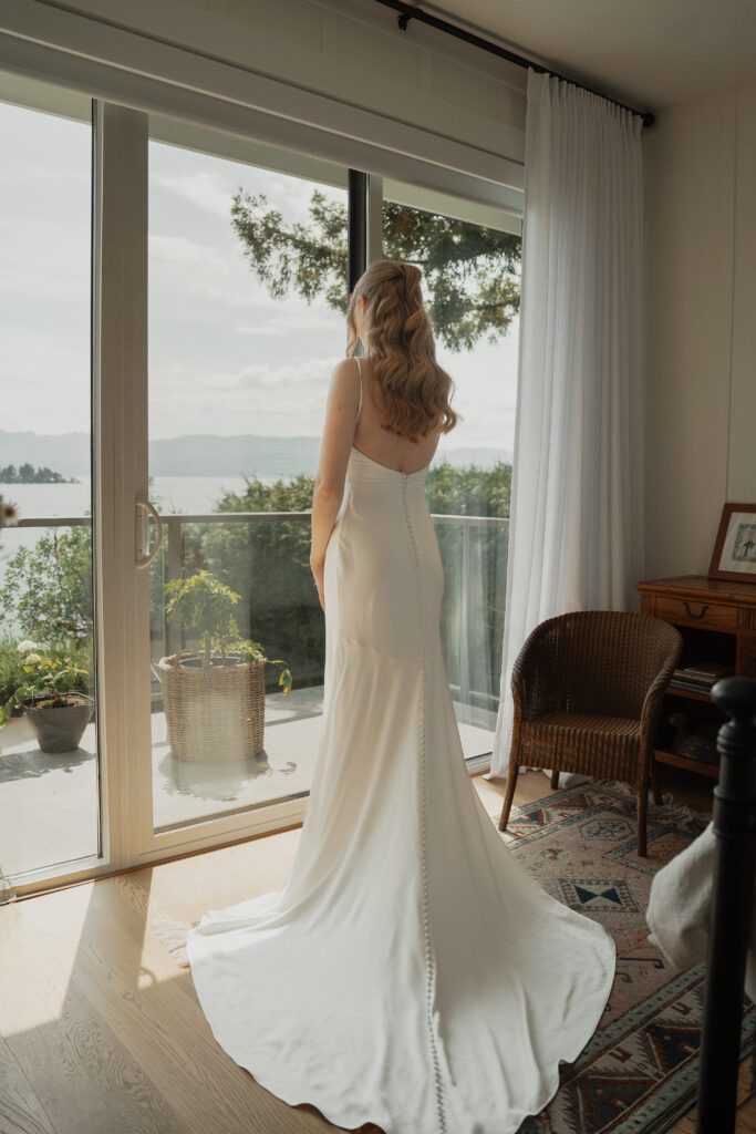 Bride after getting in her dress overlooking the ocean in Saanichton during getting ready photos by latitude 49 photograph