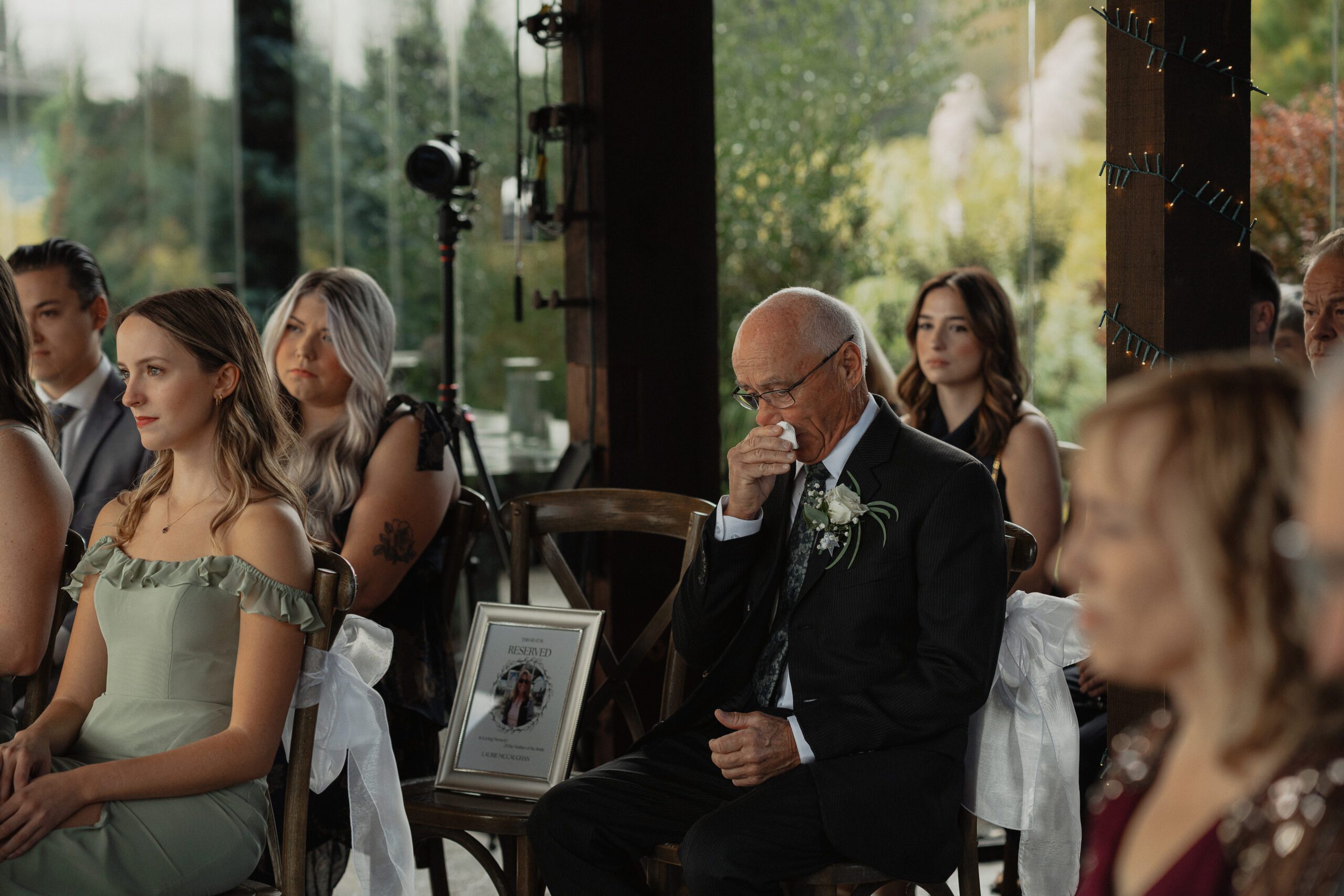 dad watching his daughter get married next to a photo of his late wife during the wedding ceremony at 40 Knots Winery by Latitude 49 Photography