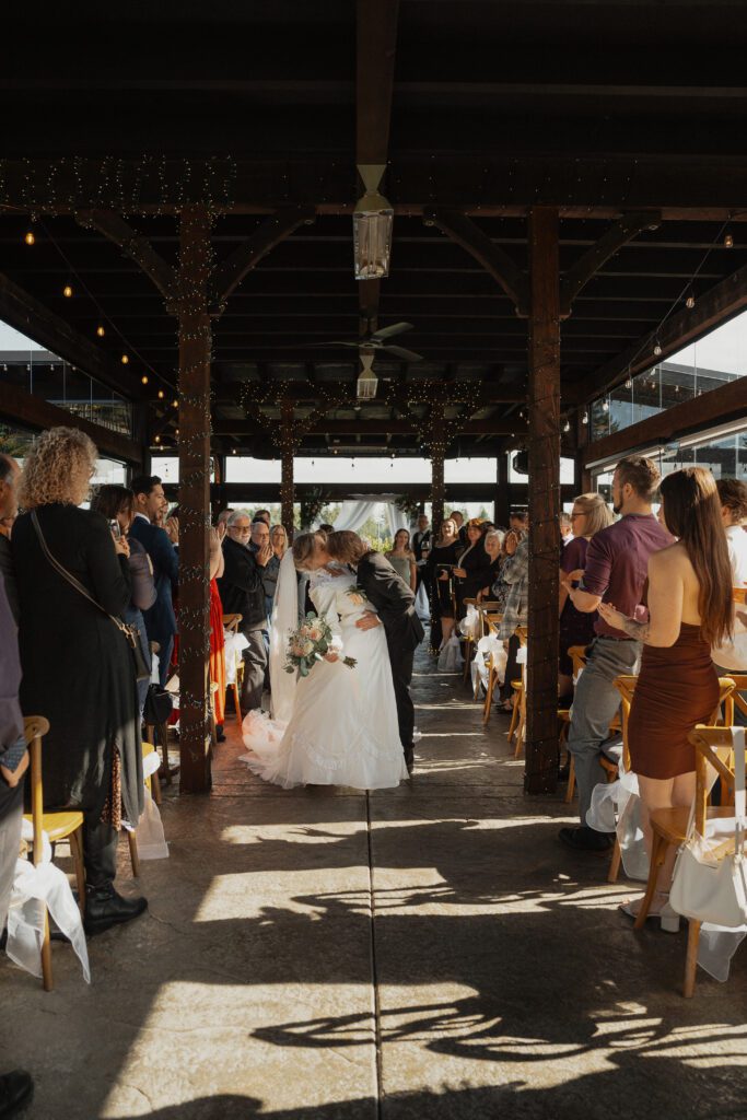 couple kissing walking down the aisle after getting married