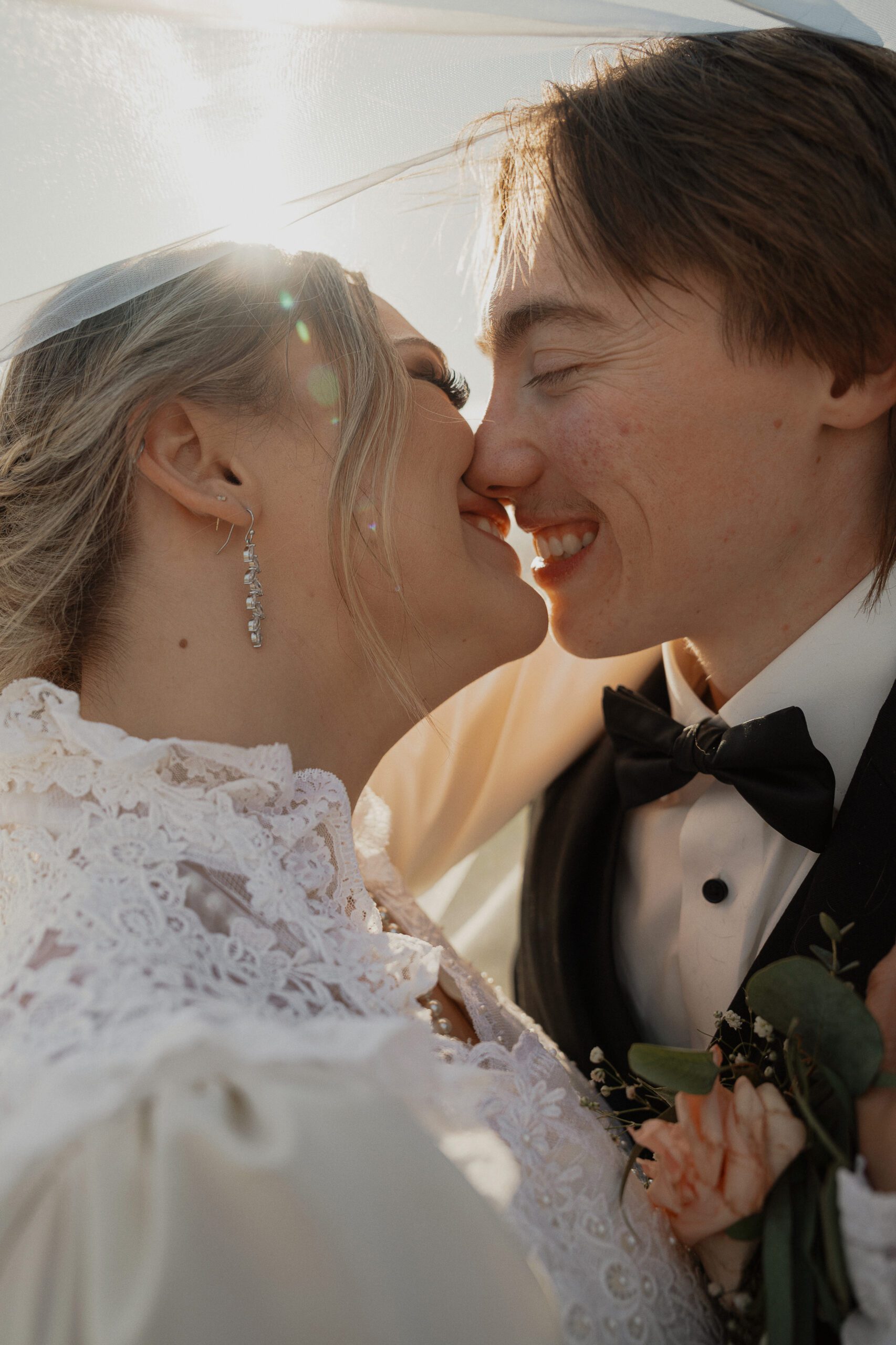 bride and groom share an almost kiss under the veil during wedding portraits in Courtenay by latitude 49 photography