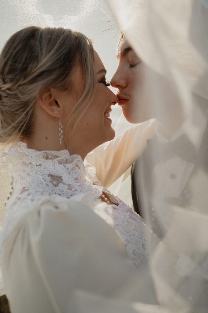 groom kisses brides nose during wedding portraits