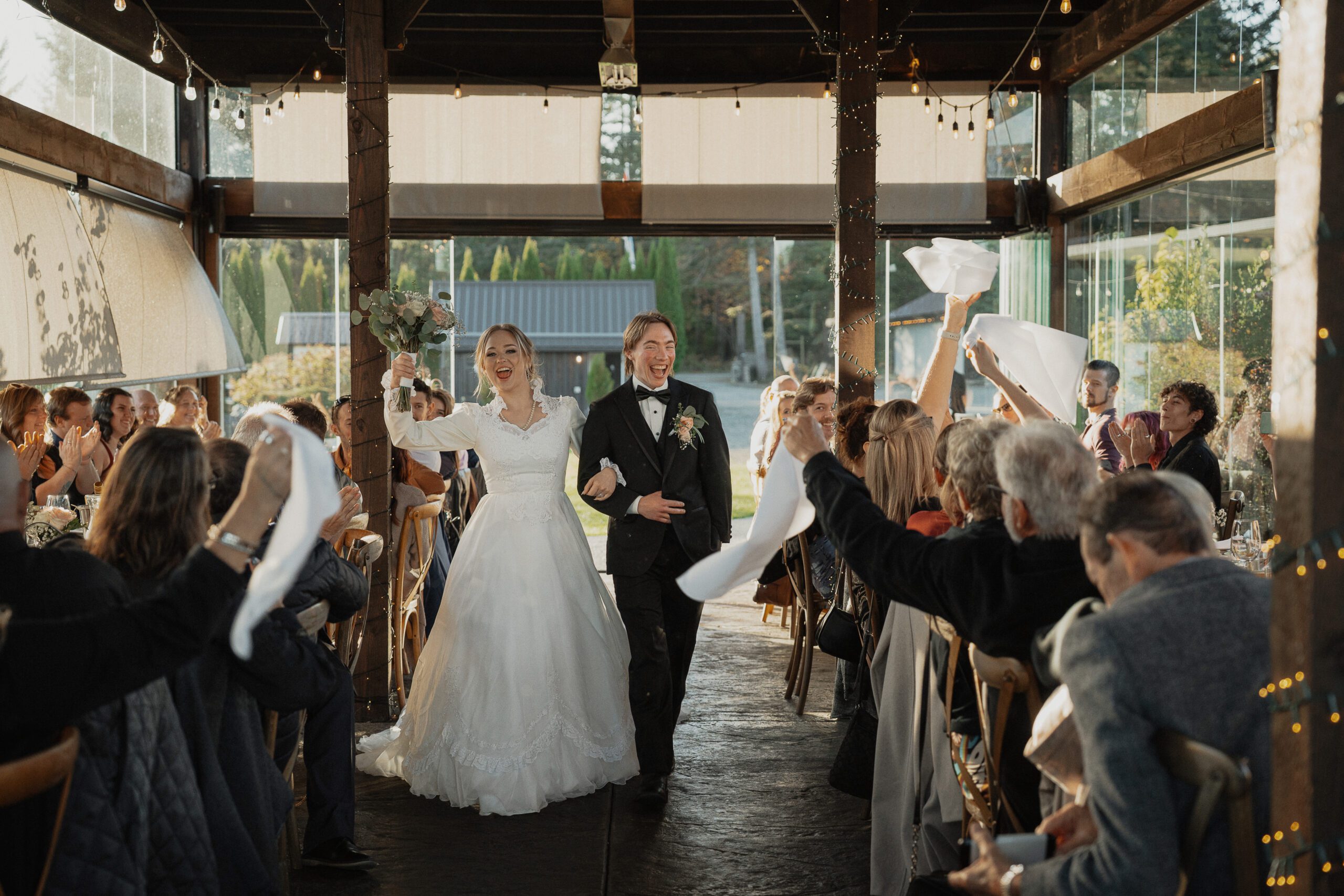 couple walking back into their reception after their wedding at 40 Knots in Comox by Latitude 49 Photography