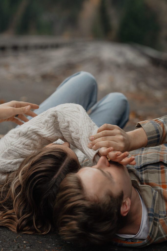 Connor kissing liz's hand during their fall engagement session at the Trestle Bridge in Campbell River.