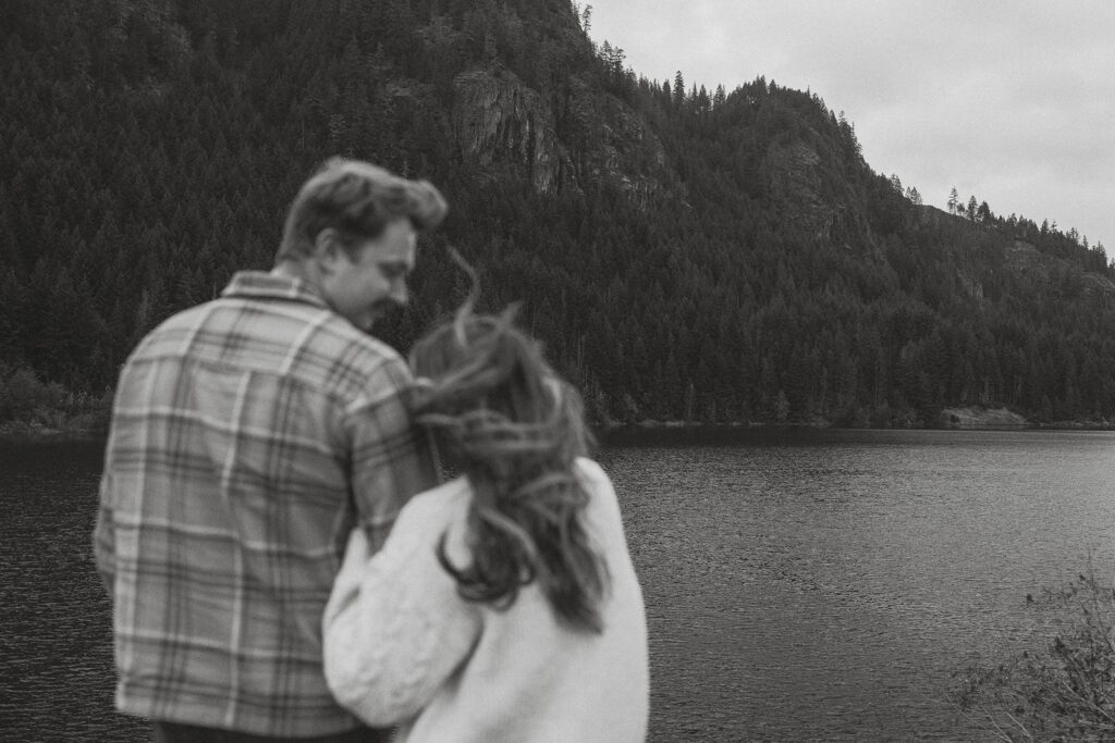 liz and connor looking at the mountains during their fall engagement session at the Trestle Bridge in Campbell River.