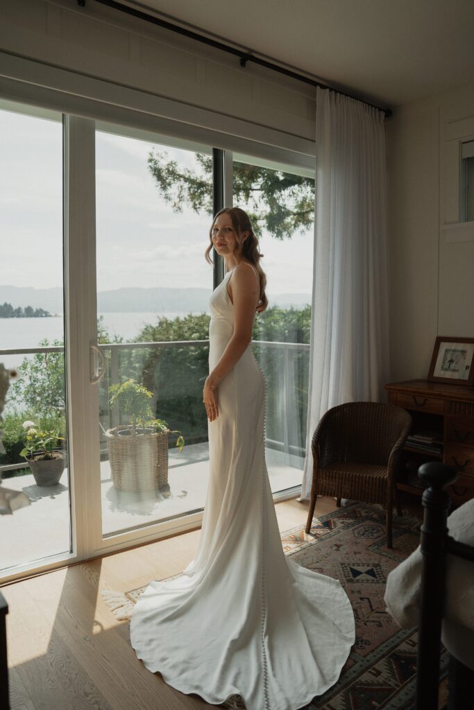 Bride after getting in her dress overlooking the ocean in Saanichton during getting ready photos by latitude 49 photograph
