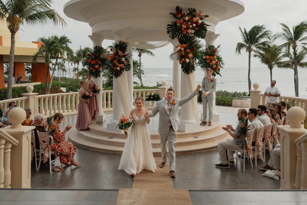Bride and groom walking down the aisle after getting married in Mexico