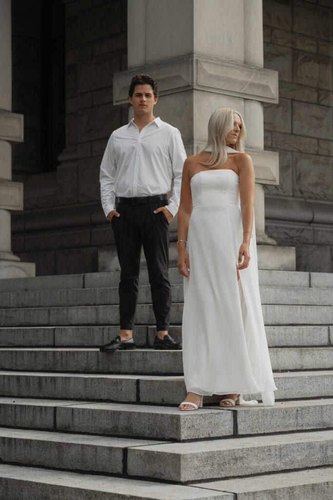 engaged couple standing on the stairs of the parliament buildings