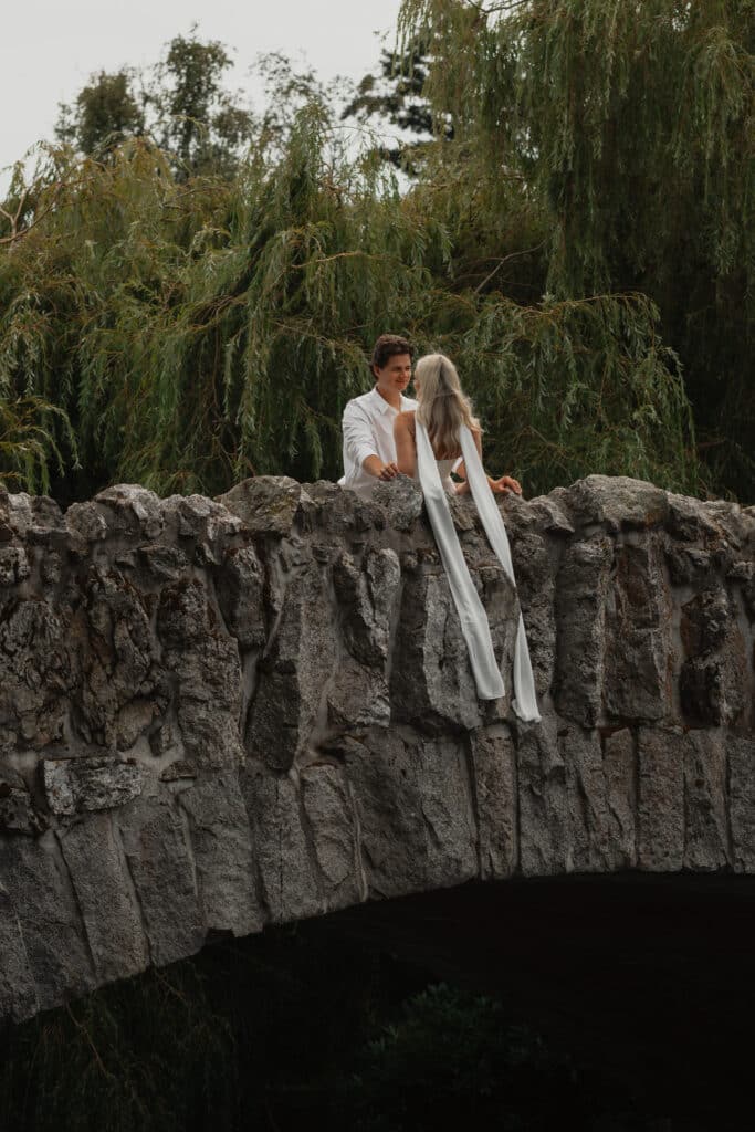 Couple leaning against the stone bridge at beacon hill park