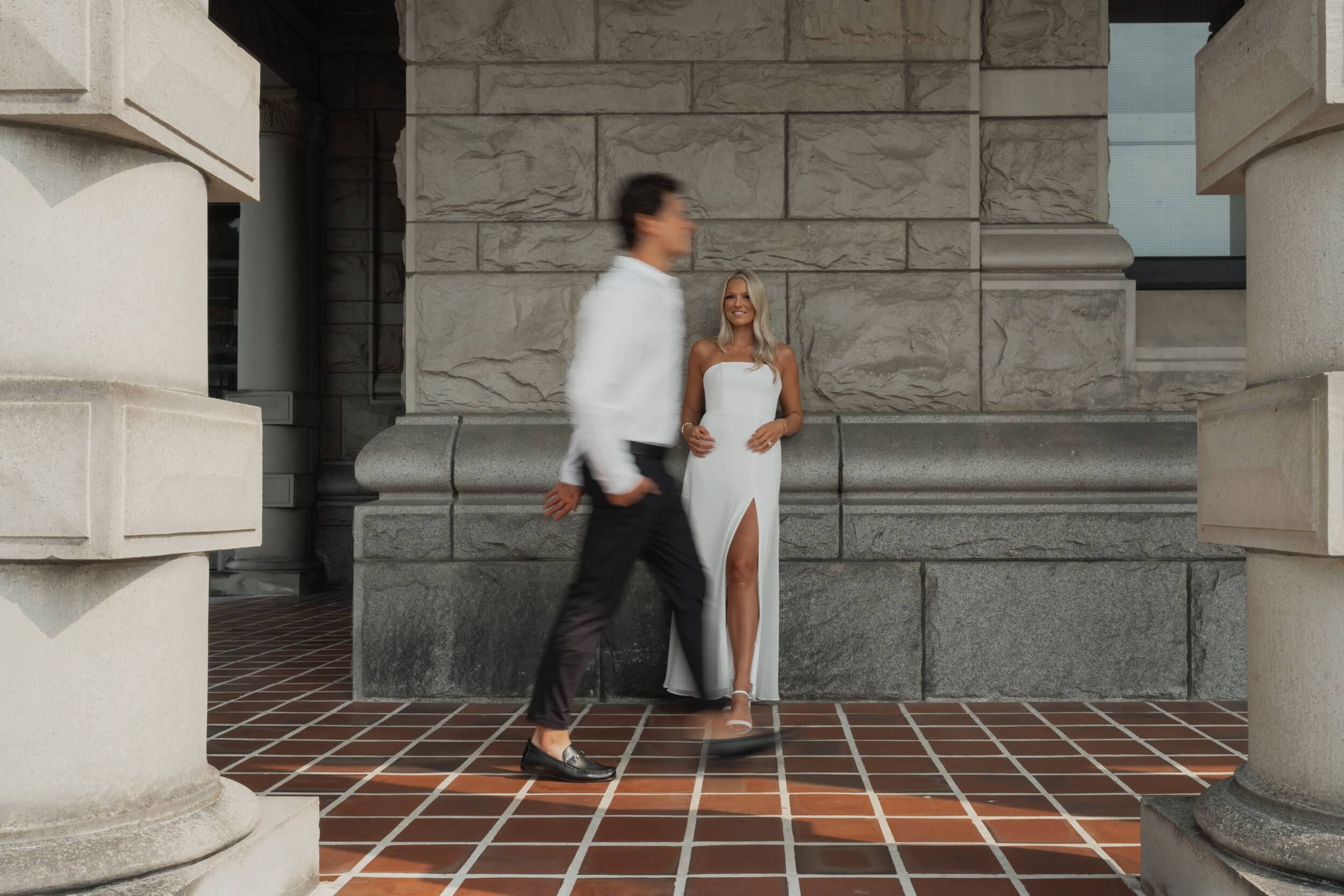 Motion photo of Aiden walking past Cassidy during their engagement session at the parliament buildings