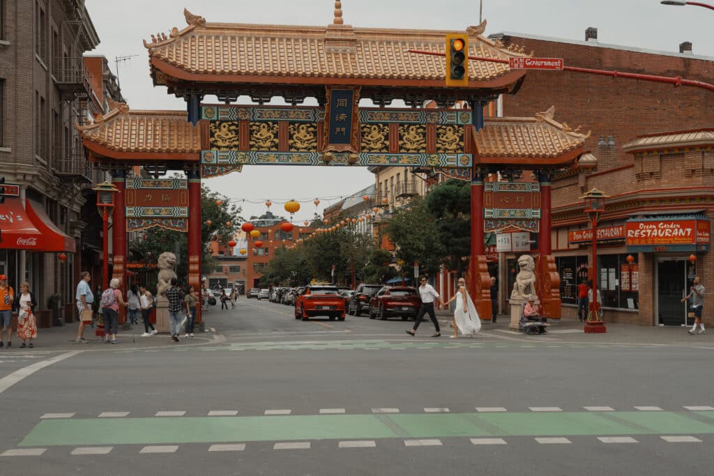 Couple walking across the street of Chinatown in Victoria