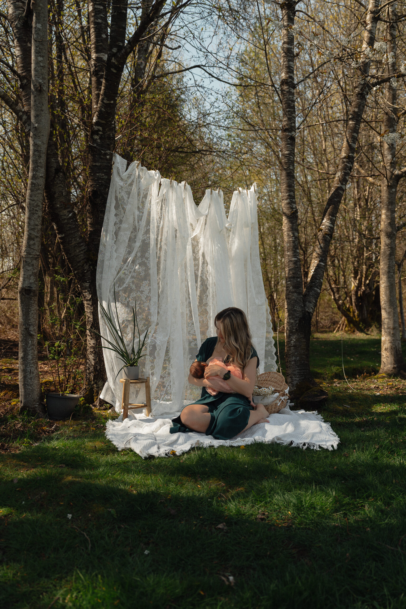 Mother cradling newborn during cozy front yard motherhood session